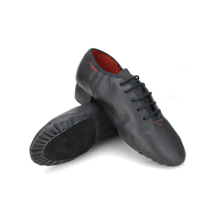 Pair of black leather boys reel shoes crossed showing suede soles and orange stitch detail