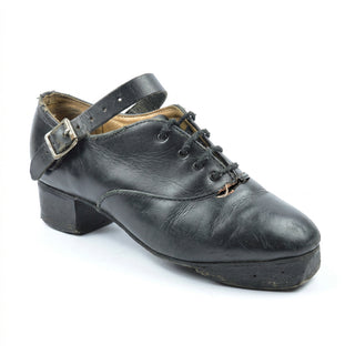 Black leather jig shoe with large toe hole showing damage needing repair